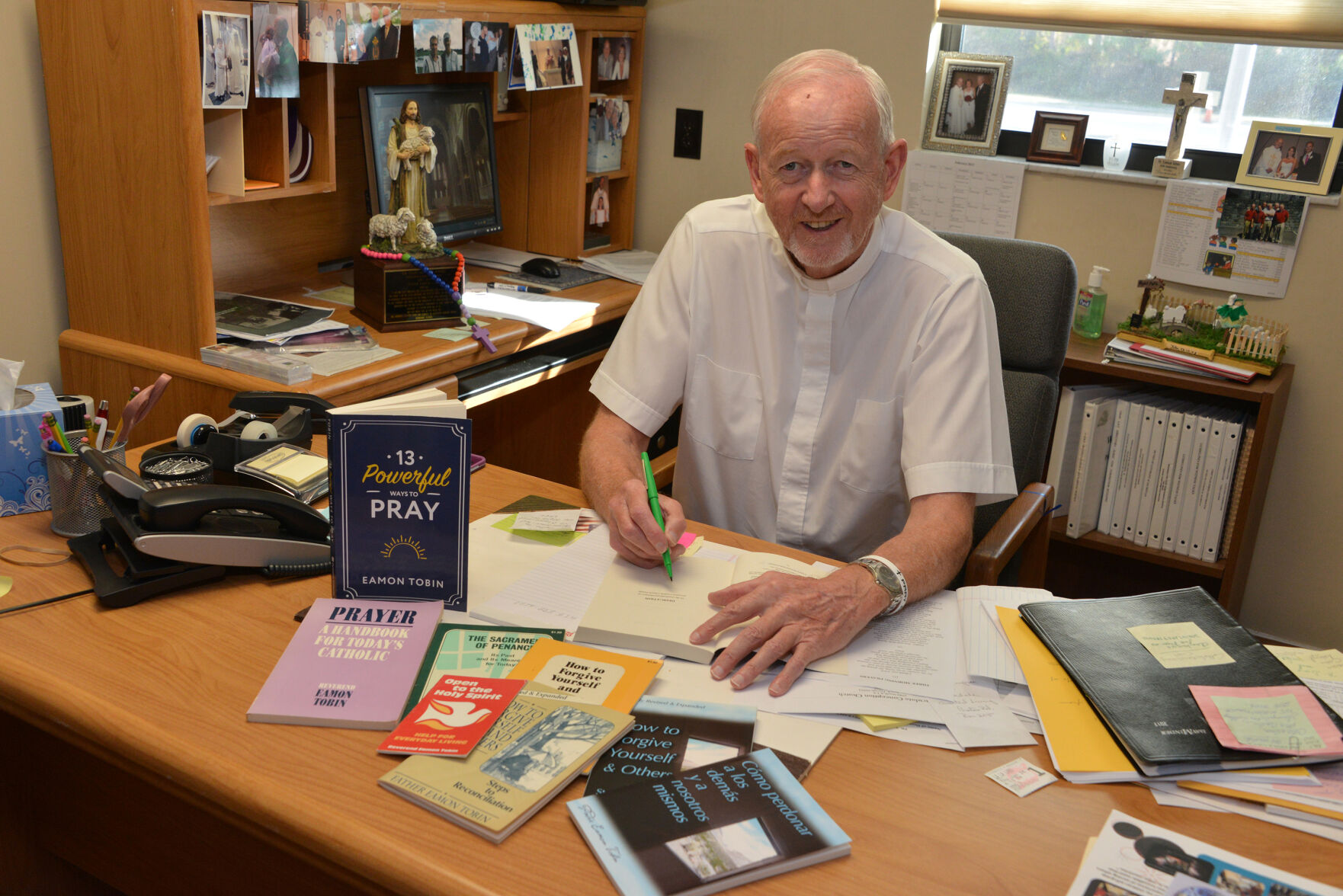 Father Eamon Tobin, pastor of Ascension Parish Melbourne sits at his writing desk in 2017 after the release of his book, “13 Powerful Ways to Pray” published by Dynamic Catholic. Father Tobin passed to eternal life Jan. 1, 2021.